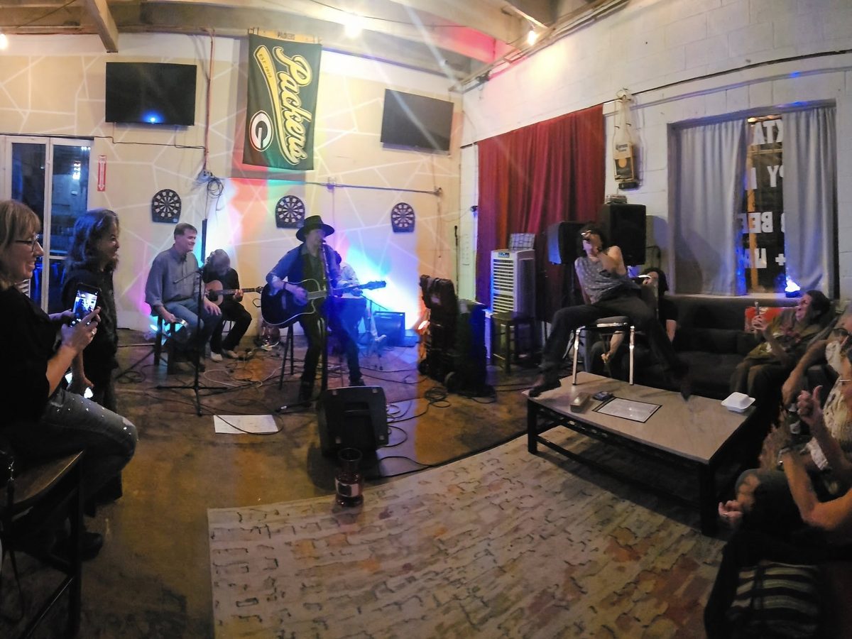 A crowd enjoying an acoustic set in the Midtown Meetup back room