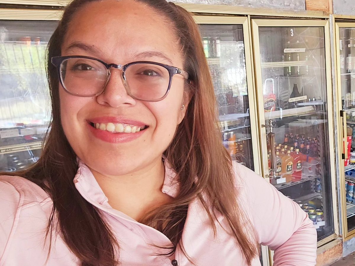 Mia, the owner of Midtown Meetup, smiling inside the shop