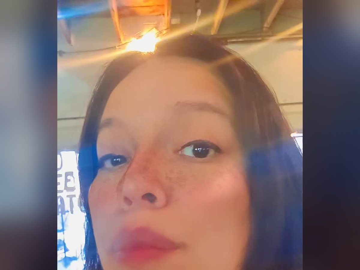 Mia smiling in a close selfie under the Midtown lights