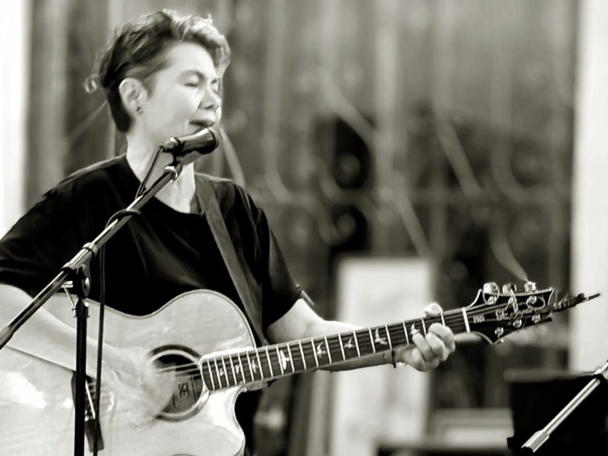 A singer with an acoustic guitar performing at Midtown