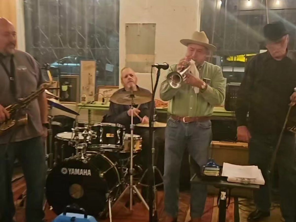 A band with a trumpet player performing inside Midtown
