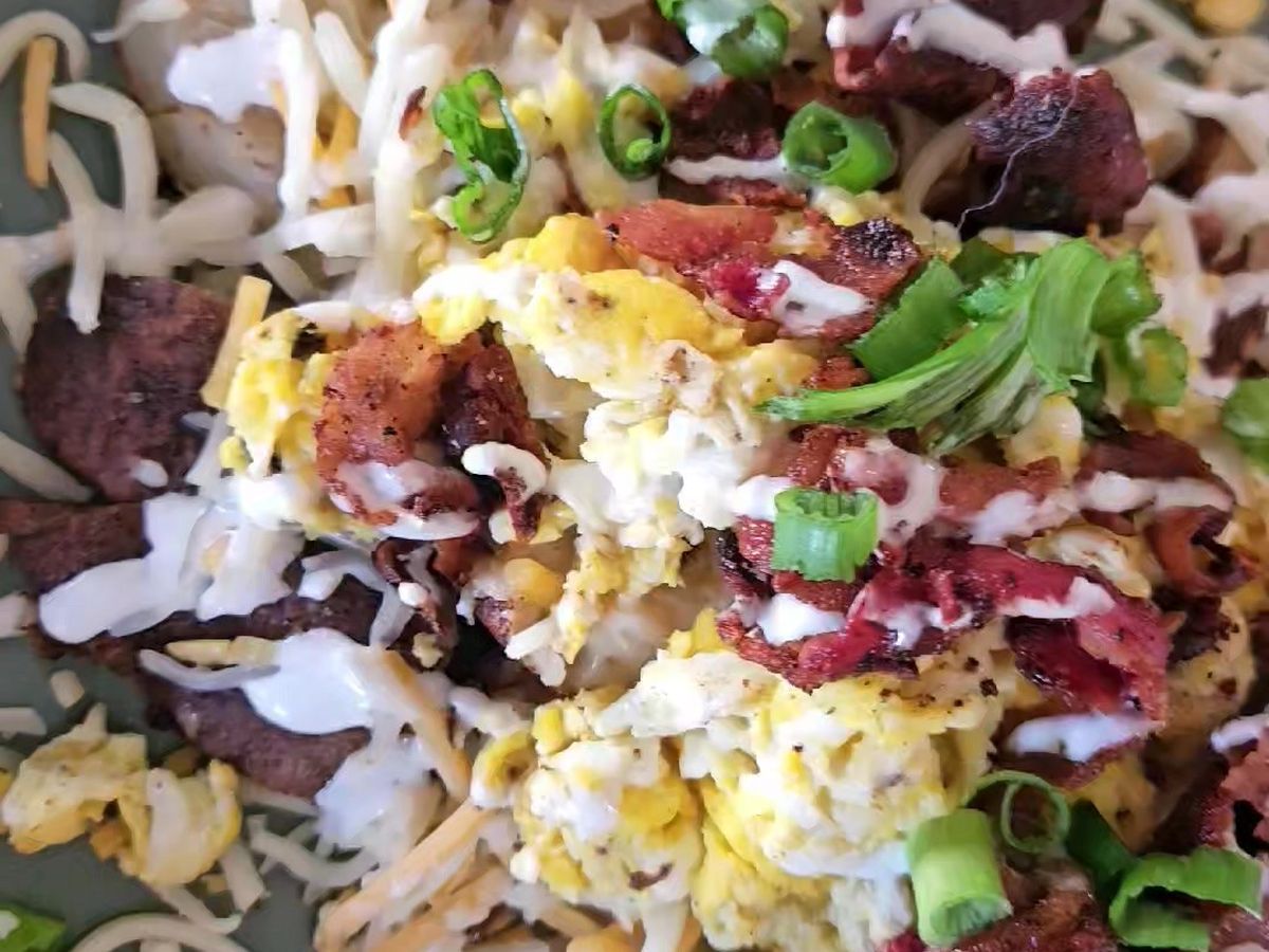 A loaded plate piled with toppings, cheese and greens