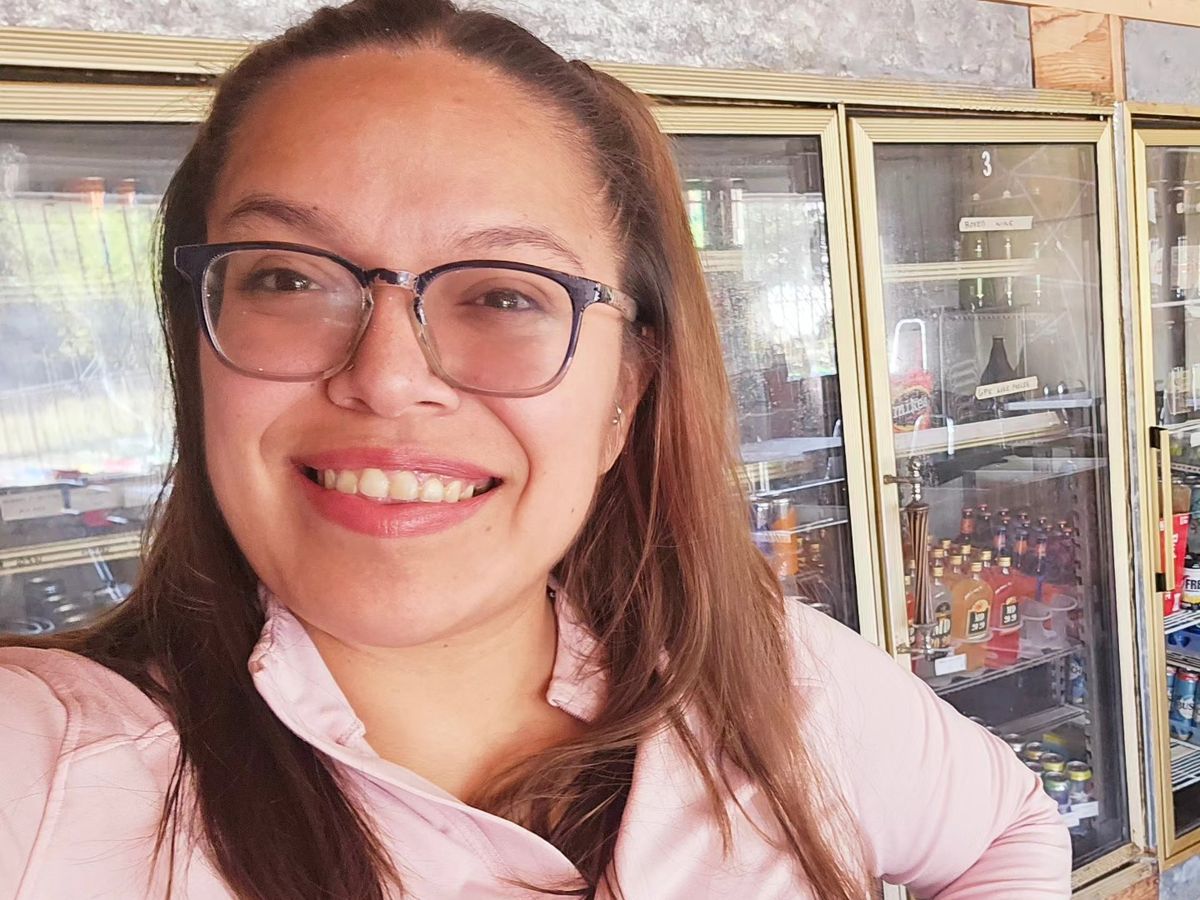 Mia, the owner of Midtown Meetup, smiling inside the shop