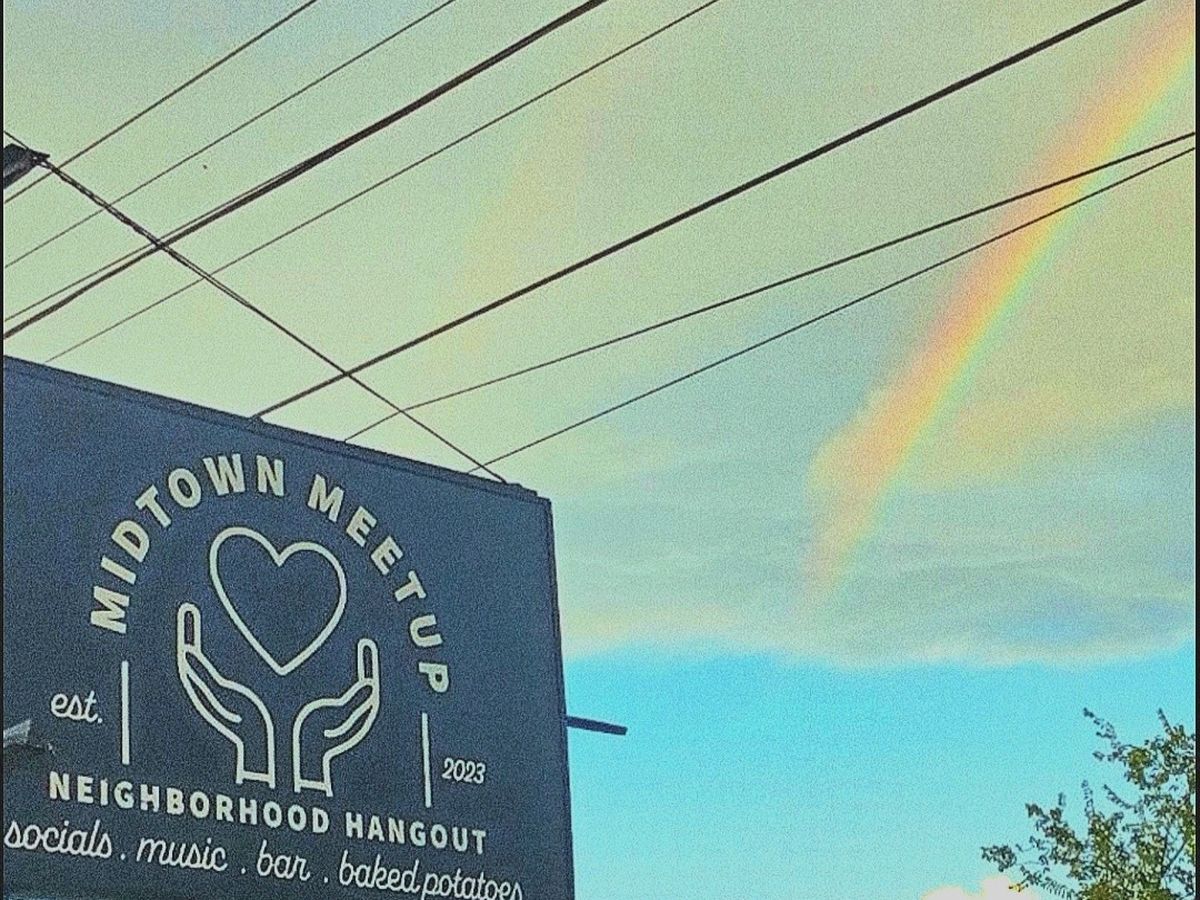 The Midtown Meetup sign under a rainbow
